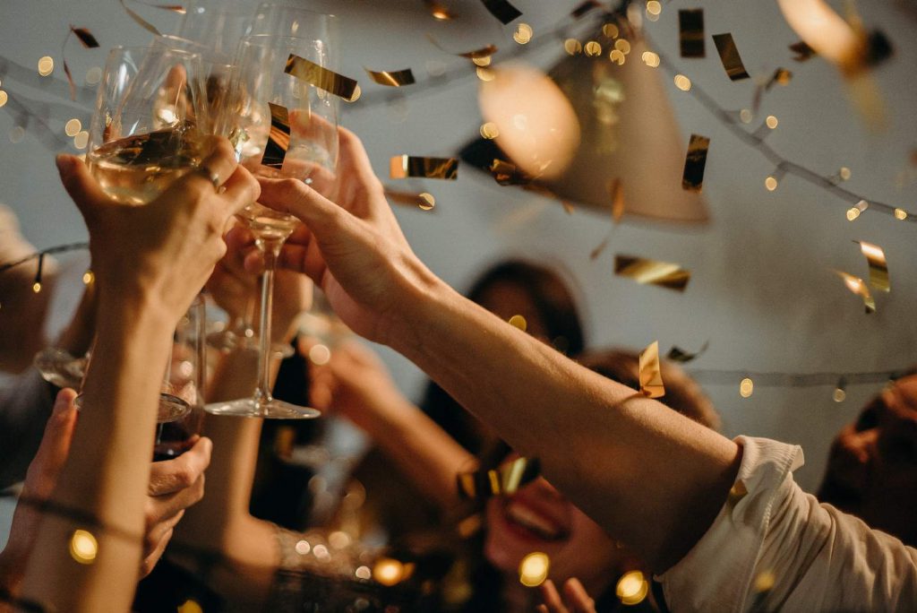 people celebrating with champagne glasses in the air at Christmas